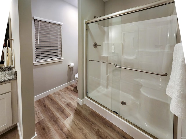 bathroom with vanity, toilet, wood-type flooring, and walk in shower