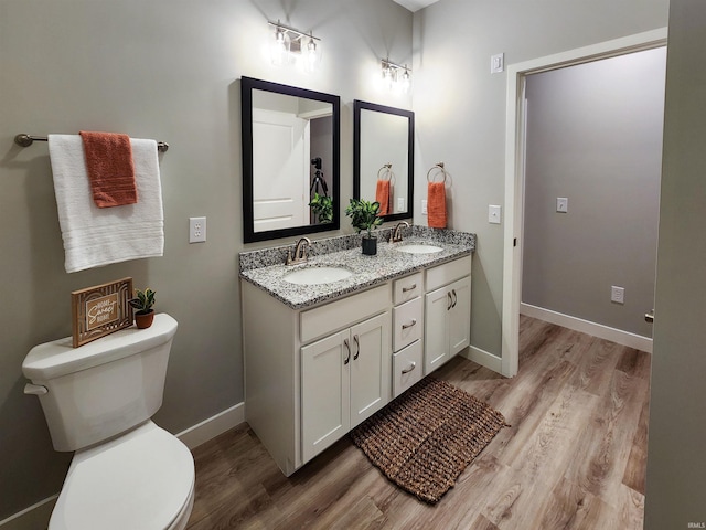 bathroom featuring vanity, wood-type flooring, and toilet