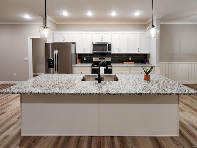 kitchen featuring decorative light fixtures, a large island with sink, and appliances with stainless steel finishes