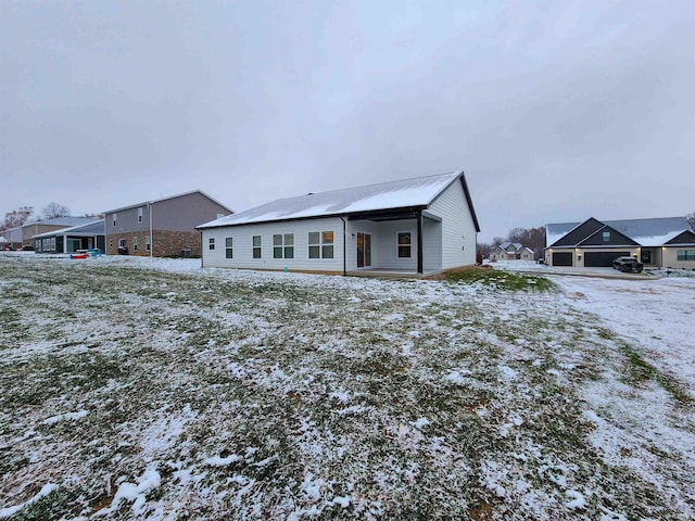 view of snow covered rear of property