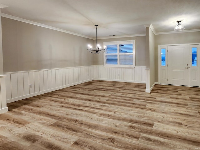 entryway featuring a notable chandelier, light wood-type flooring, and crown molding