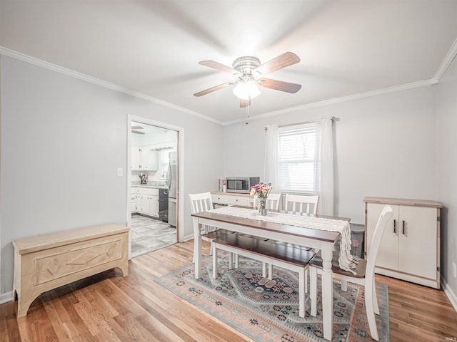 dining space featuring light hardwood / wood-style flooring, ceiling fan, and crown molding