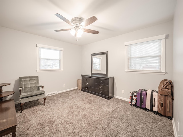 living area with plenty of natural light, ceiling fan, and carpet floors