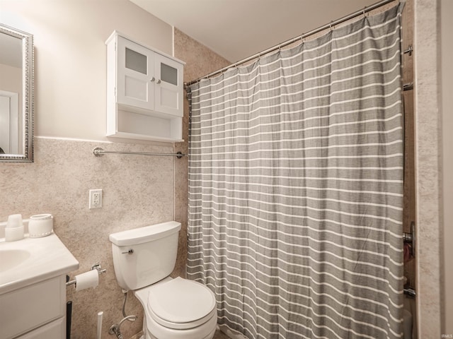 bathroom with vanity, toilet, and tile walls