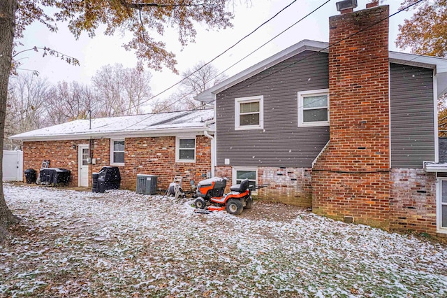 snow covered house featuring cooling unit