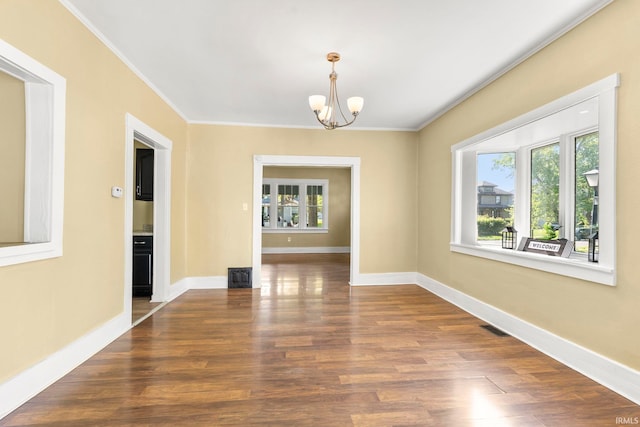 unfurnished dining area with a notable chandelier, dark hardwood / wood-style floors, and ornamental molding