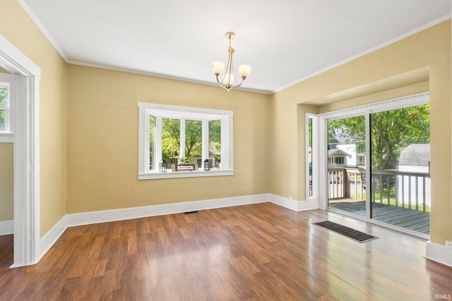 spare room with crown molding, an inviting chandelier, and hardwood / wood-style flooring