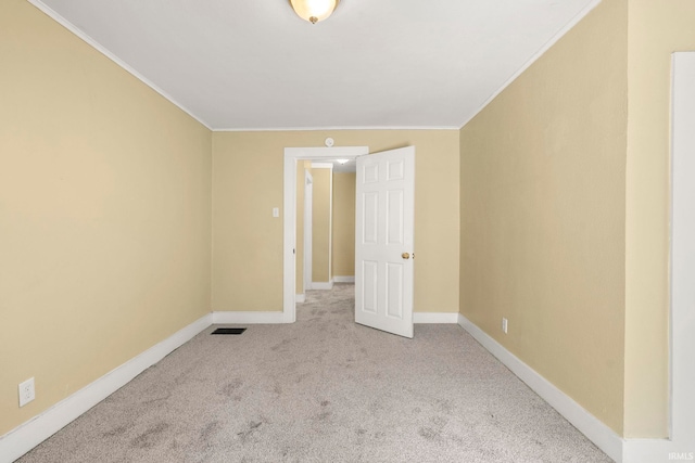 unfurnished room featuring light carpet and crown molding