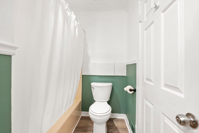 bathroom with shower / bath combination with curtain, crown molding, tile walls, hardwood / wood-style floors, and toilet