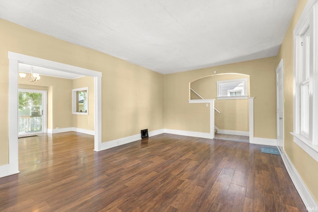 unfurnished room featuring dark hardwood / wood-style floors, a textured ceiling, and an inviting chandelier