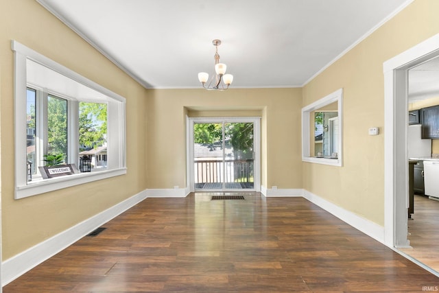 unfurnished dining area featuring a chandelier, crown molding, and dark wood-type flooring