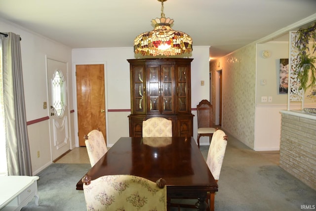 dining room featuring light colored carpet and crown molding