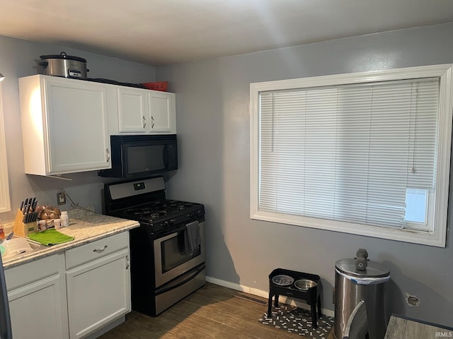 kitchen with stainless steel gas range oven, white cabinetry, sink, and dark wood-type flooring