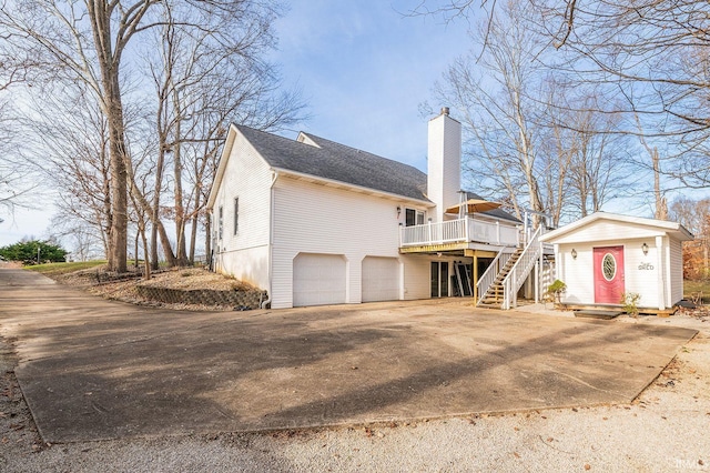 view of home's exterior featuring a garage, a shed, and a deck