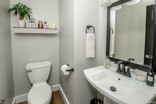 bathroom featuring wood-type flooring, toilet, and sink