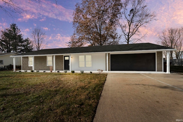 ranch-style home featuring a garage and a lawn