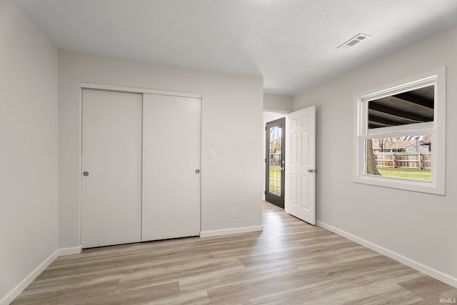 unfurnished bedroom featuring light hardwood / wood-style floors and a closet