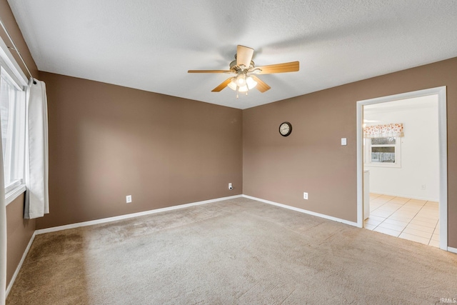 carpeted empty room with plenty of natural light, a textured ceiling, and ceiling fan