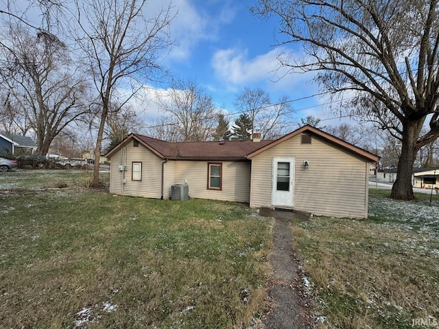 rear view of house with a yard and cooling unit