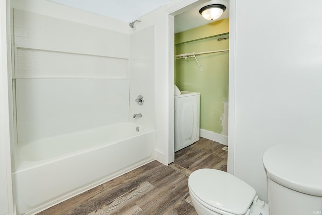 bathroom featuring washer / clothes dryer, toilet, tub / shower combination, and hardwood / wood-style flooring