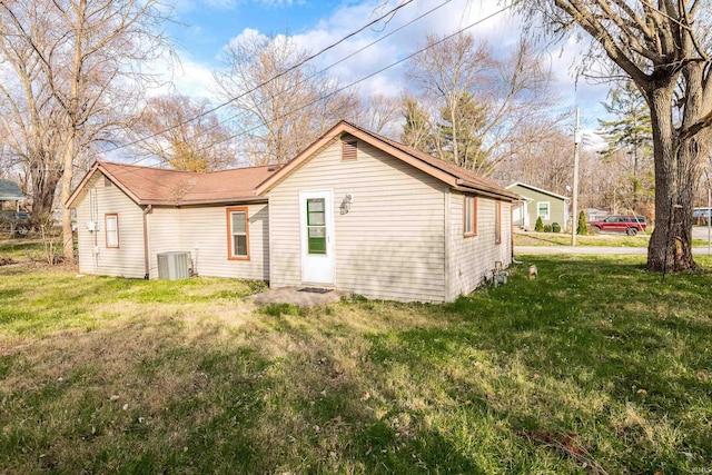 back of property featuring a yard and central air condition unit