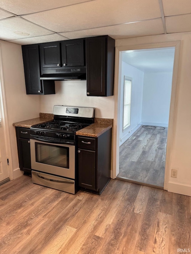 kitchen featuring a paneled ceiling, light hardwood / wood-style flooring, and stainless steel range with gas stovetop