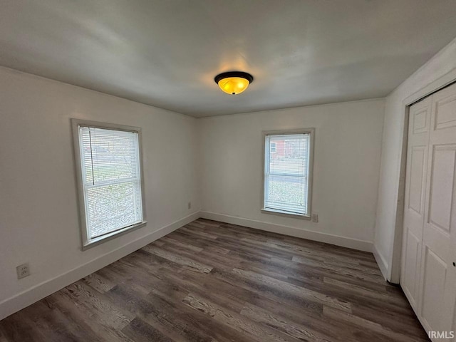 unfurnished bedroom featuring dark hardwood / wood-style flooring and a closet