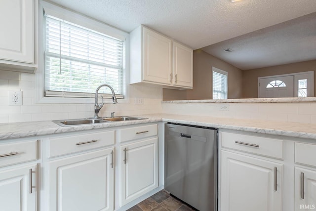 kitchen featuring stainless steel dishwasher, white cabinets, sink, and a textured ceiling