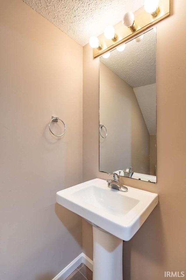 bathroom with tile patterned flooring and a textured ceiling