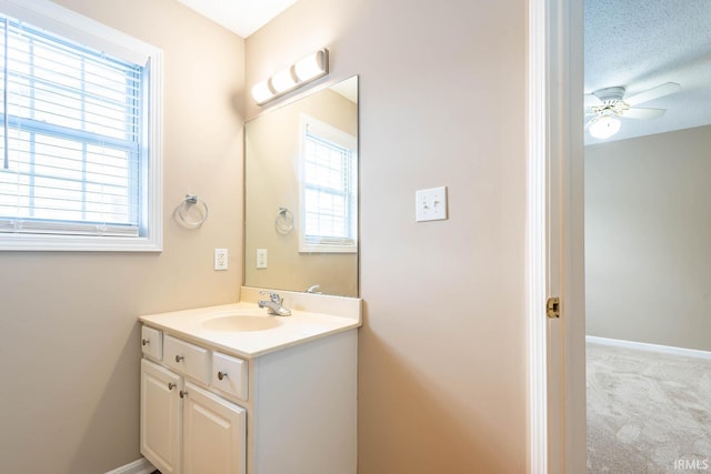 bathroom with a textured ceiling, vanity, a wealth of natural light, and ceiling fan