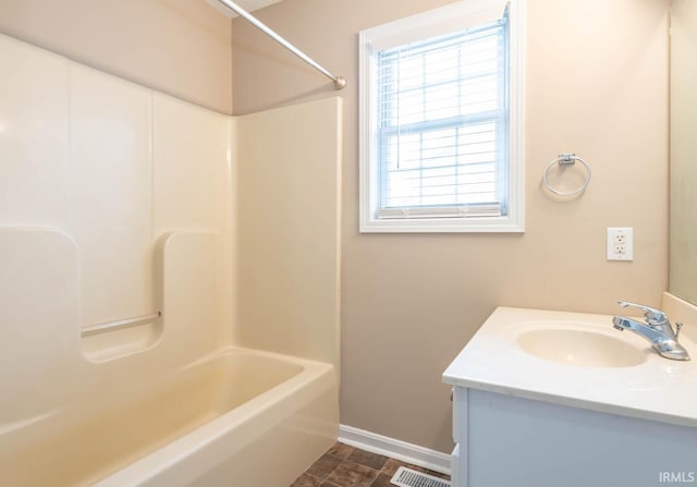 bathroom featuring vanity, a healthy amount of sunlight, and shower / washtub combination