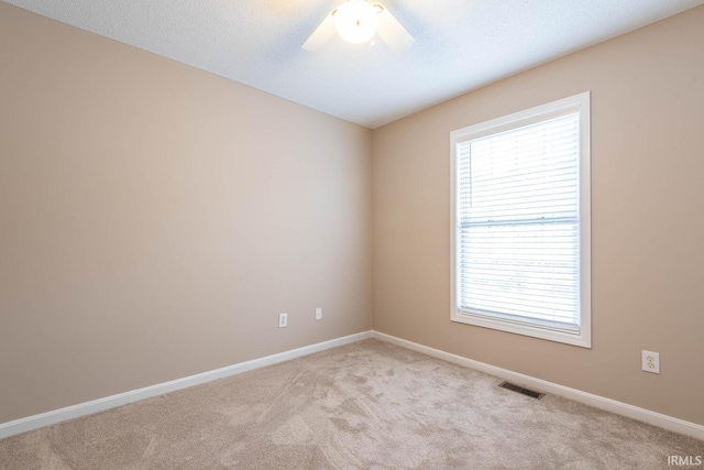 carpeted spare room featuring ceiling fan