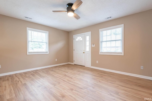 foyer entrance featuring ceiling fan, light hardwood / wood-style flooring, and a textured ceiling