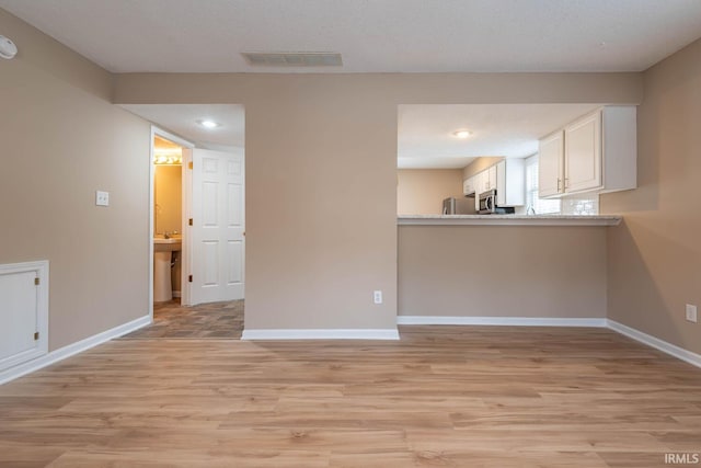 interior space featuring light hardwood / wood-style flooring and a textured ceiling