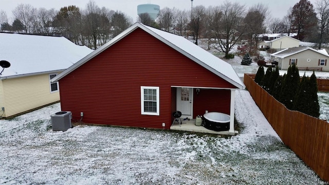 snow covered property with central AC unit