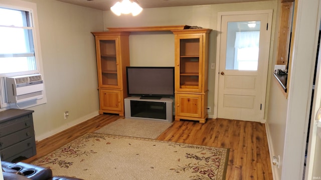 unfurnished living room with hardwood / wood-style floors, ceiling fan, and cooling unit