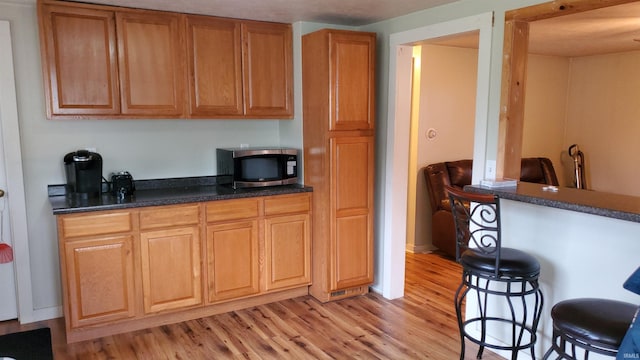 kitchen with light hardwood / wood-style floors and a breakfast bar area