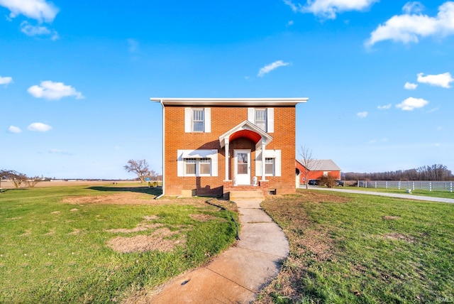 view of front of home with a rural view and a front yard