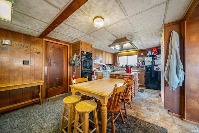 dining area featuring wooden walls and light colored carpet