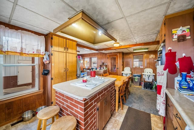 kitchen featuring white electric stovetop, wood walls, and light carpet