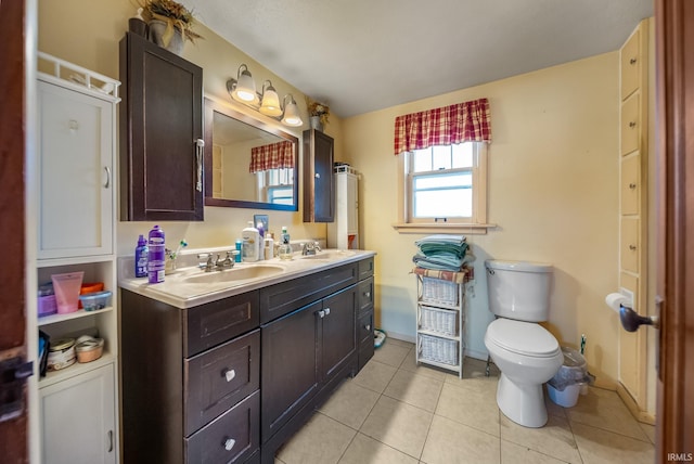 bathroom with toilet, vanity, and tile patterned floors