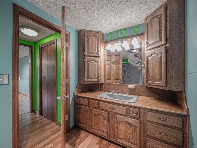 bathroom featuring hardwood / wood-style floors, vanity, and a textured ceiling