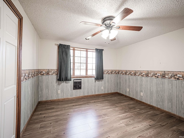 empty room featuring ceiling fan, a textured ceiling, and light hardwood / wood-style flooring