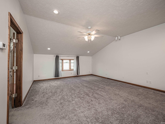 unfurnished room with ceiling fan, lofted ceiling, a textured ceiling, and carpet floors