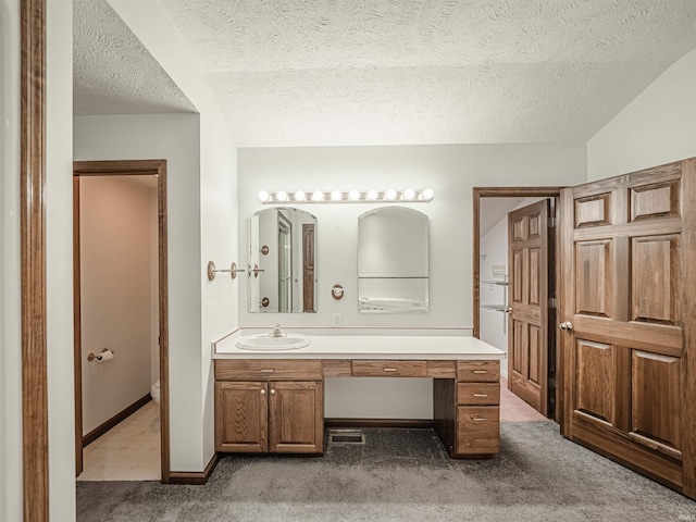 bathroom with vanity, a textured ceiling, and toilet