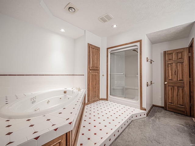 bathroom with a textured ceiling and shower with separate bathtub