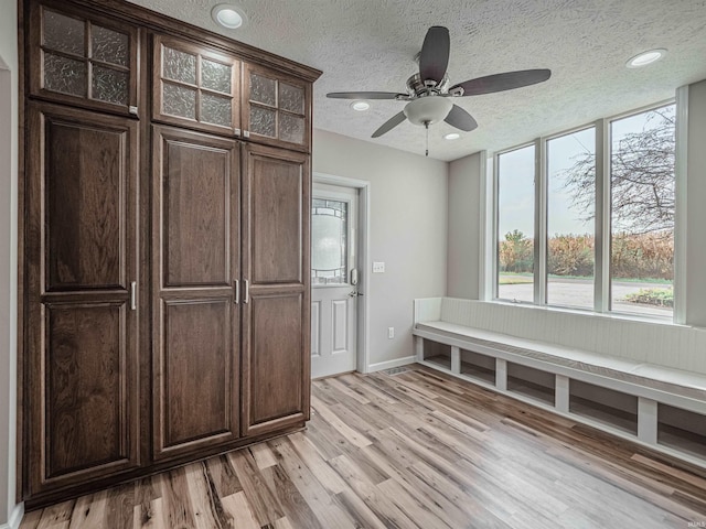 mudroom featuring a textured ceiling, light hardwood / wood-style flooring, and ceiling fan