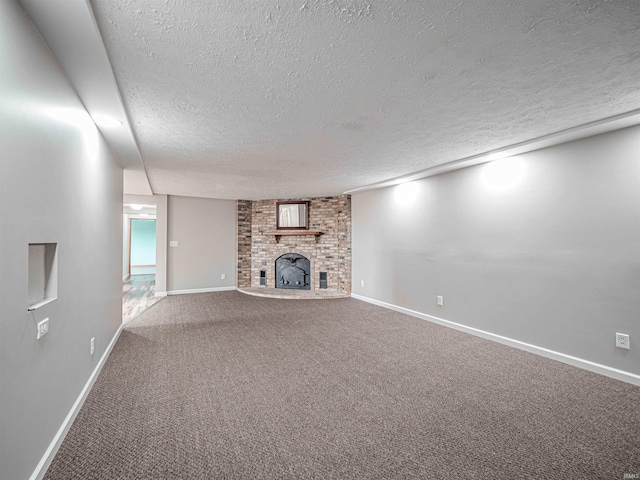 unfurnished living room featuring a textured ceiling, carpet floors, and a fireplace