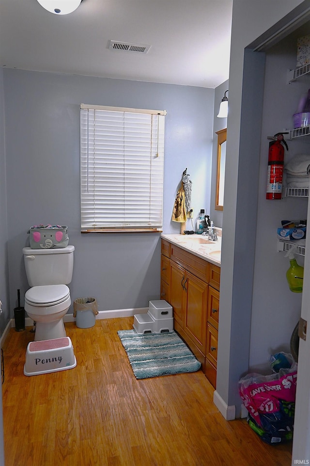 bathroom with vanity, hardwood / wood-style flooring, and toilet