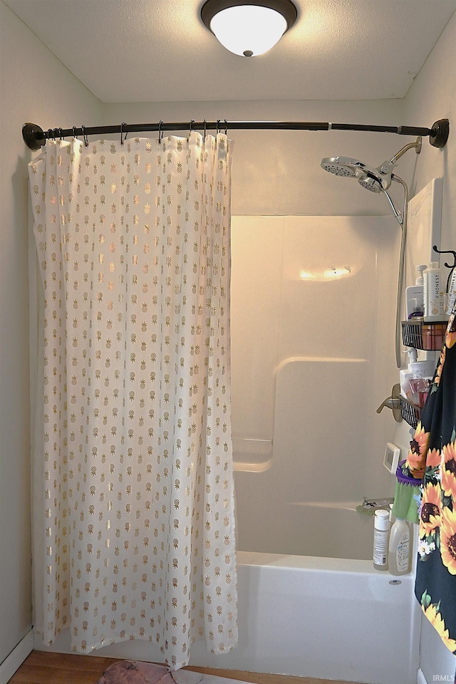 bathroom featuring shower / bath combination with curtain, a textured ceiling, and wood-type flooring